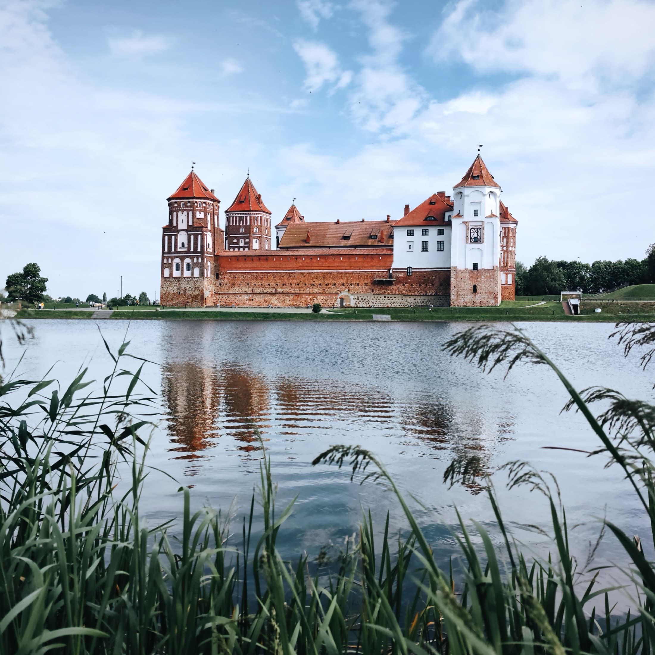 Mir Castle reflected in the still waters of its surrounding lake