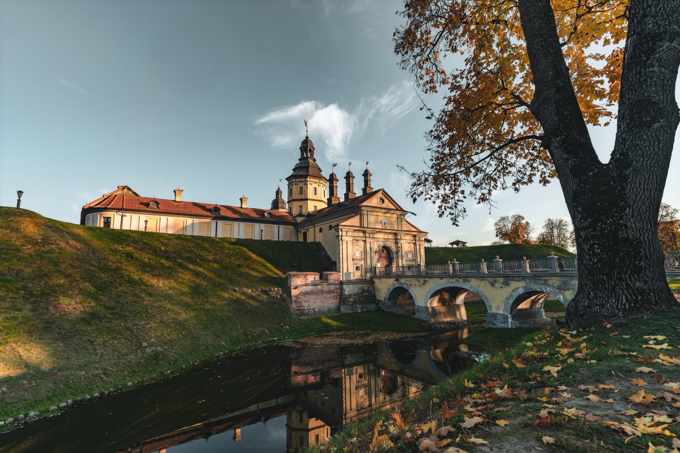 The bridge over the moat leading to the entrance of Nesvizh Radziwill Castle in autumn