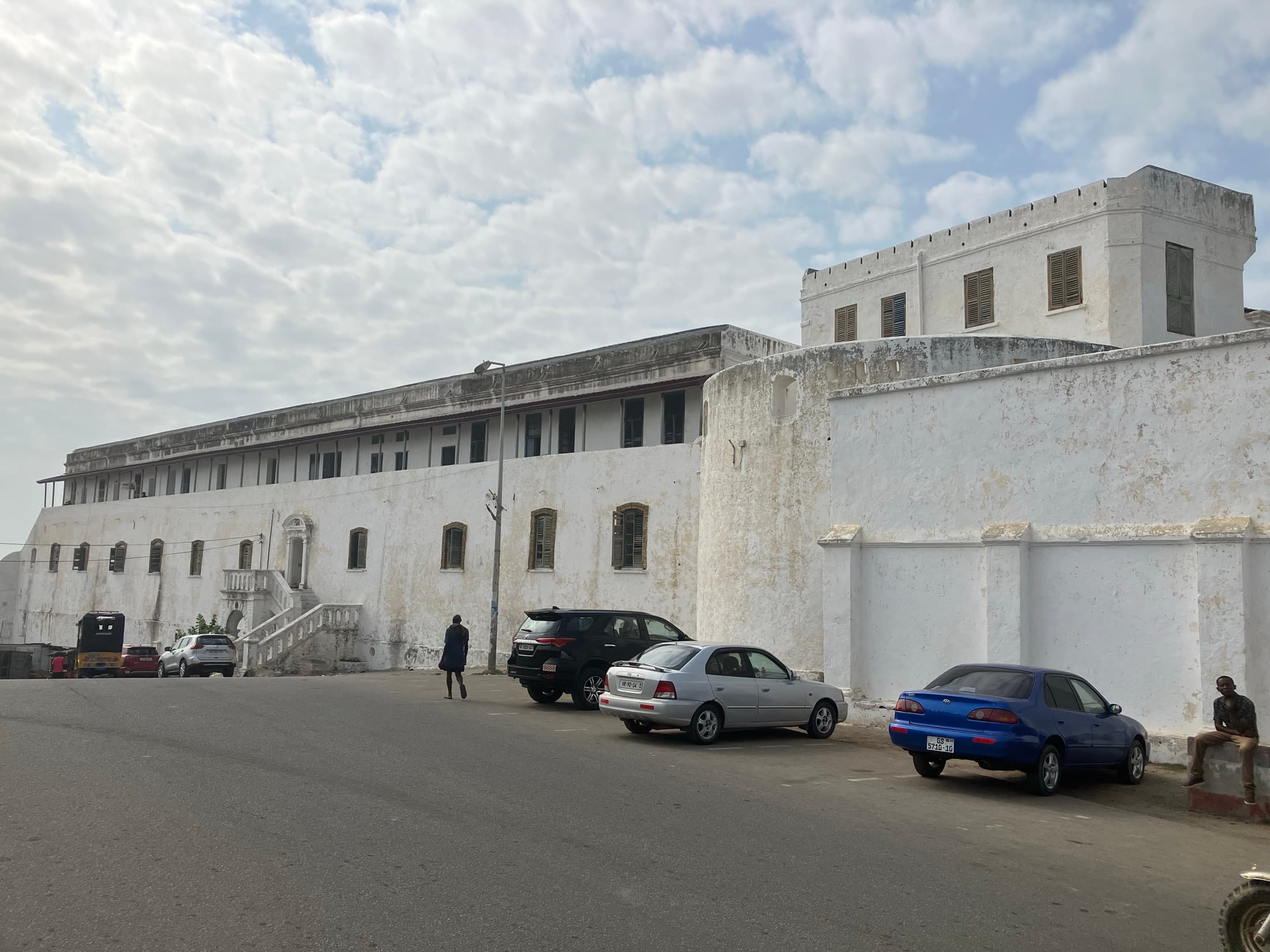 Street view of the historic whitewashed walls of Cape Coast Castle
