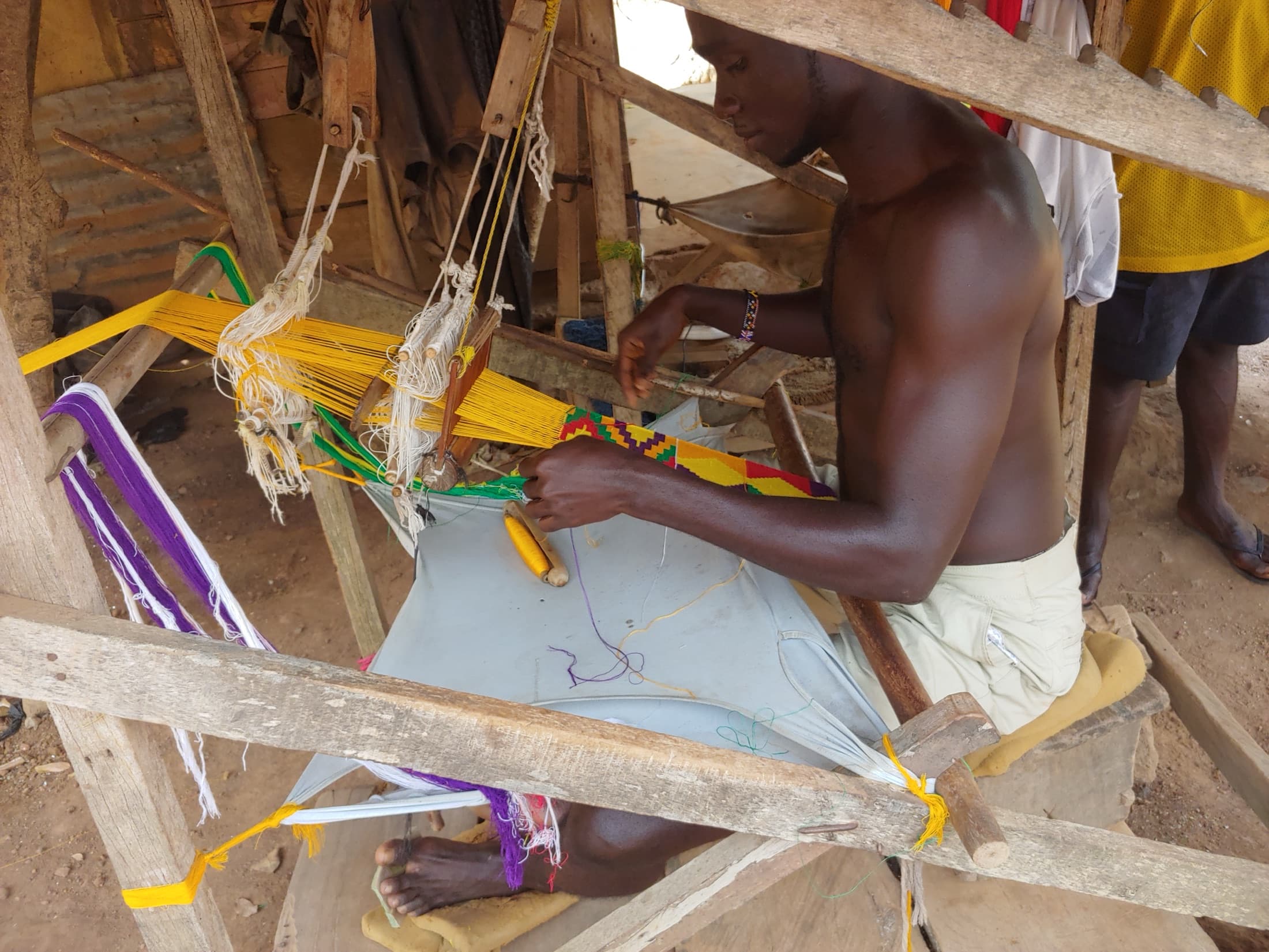 A craftsman weaving kente cloth on a traditional loom in Bonwire, near Kumasi
