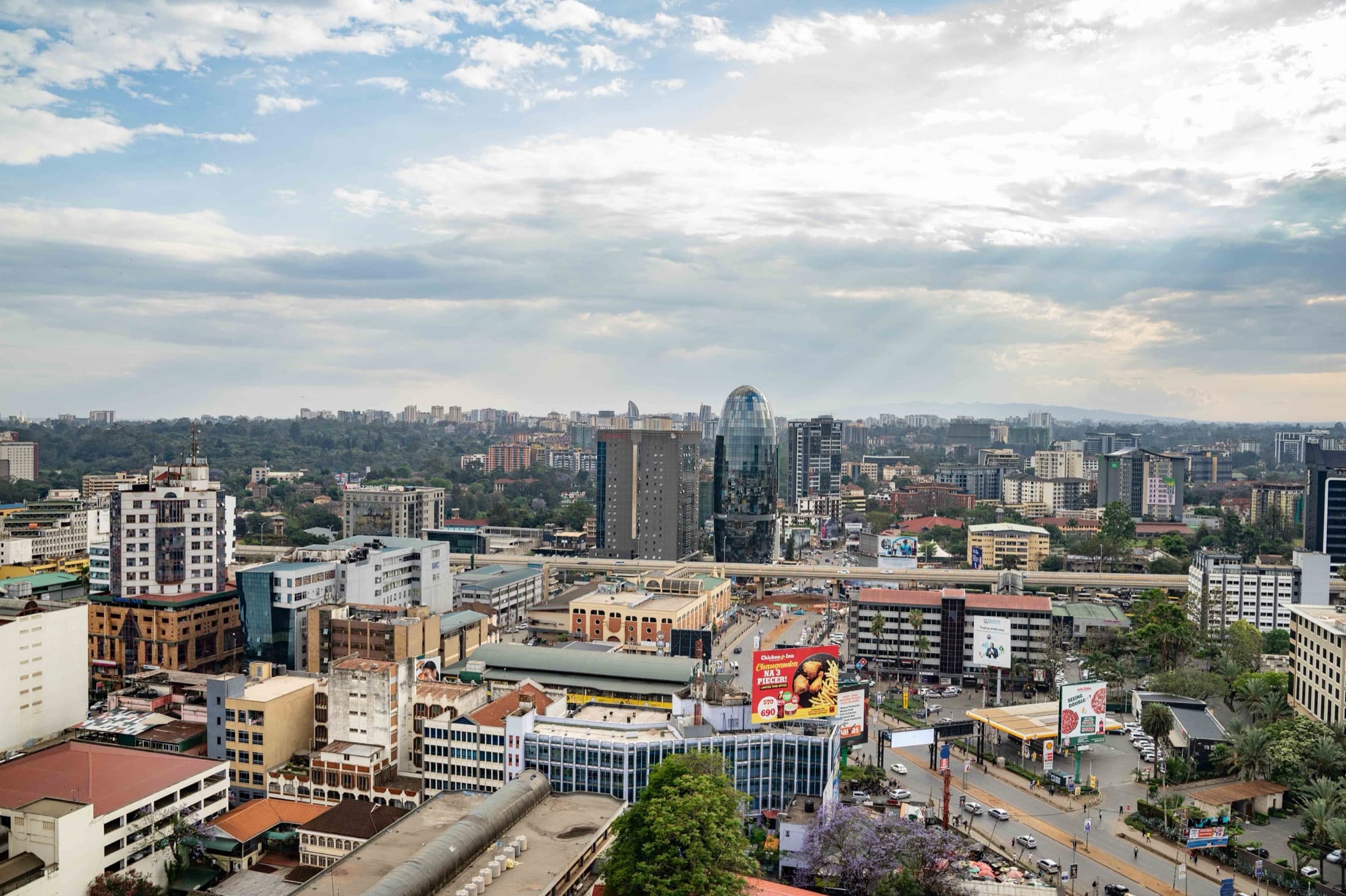 Aerial view of Nairobi's bustling cityscape with modern architecture under a partly cloudy sky