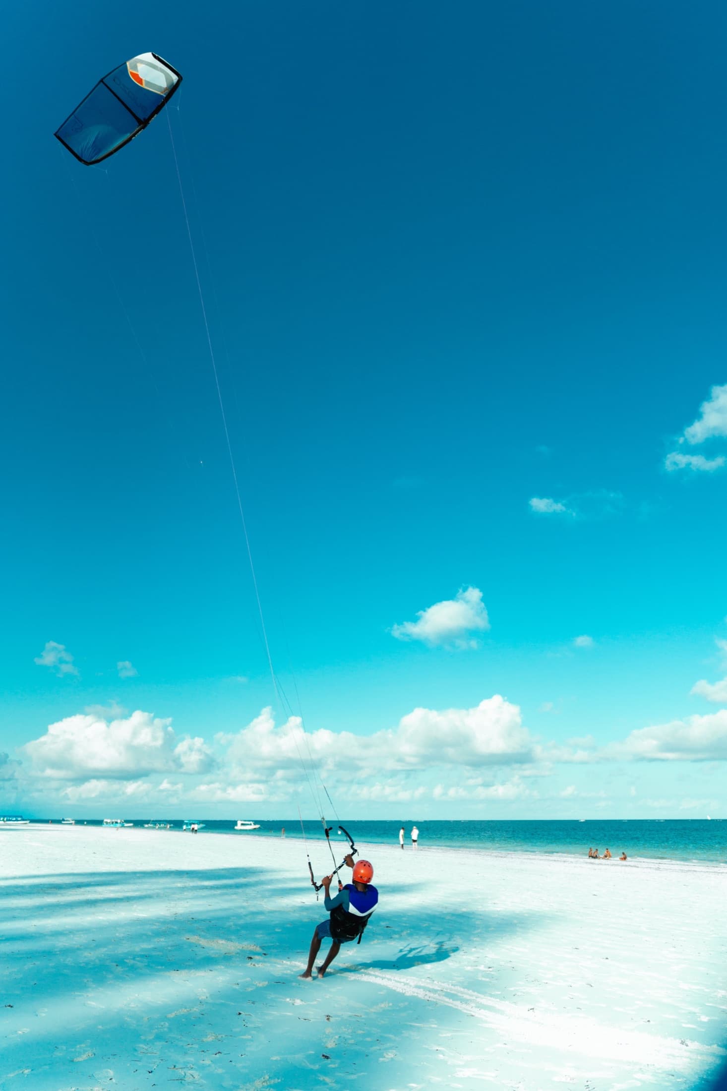 A kitesurfer on the pristine white sands and turquoise waters of Diani Beach, Kenya