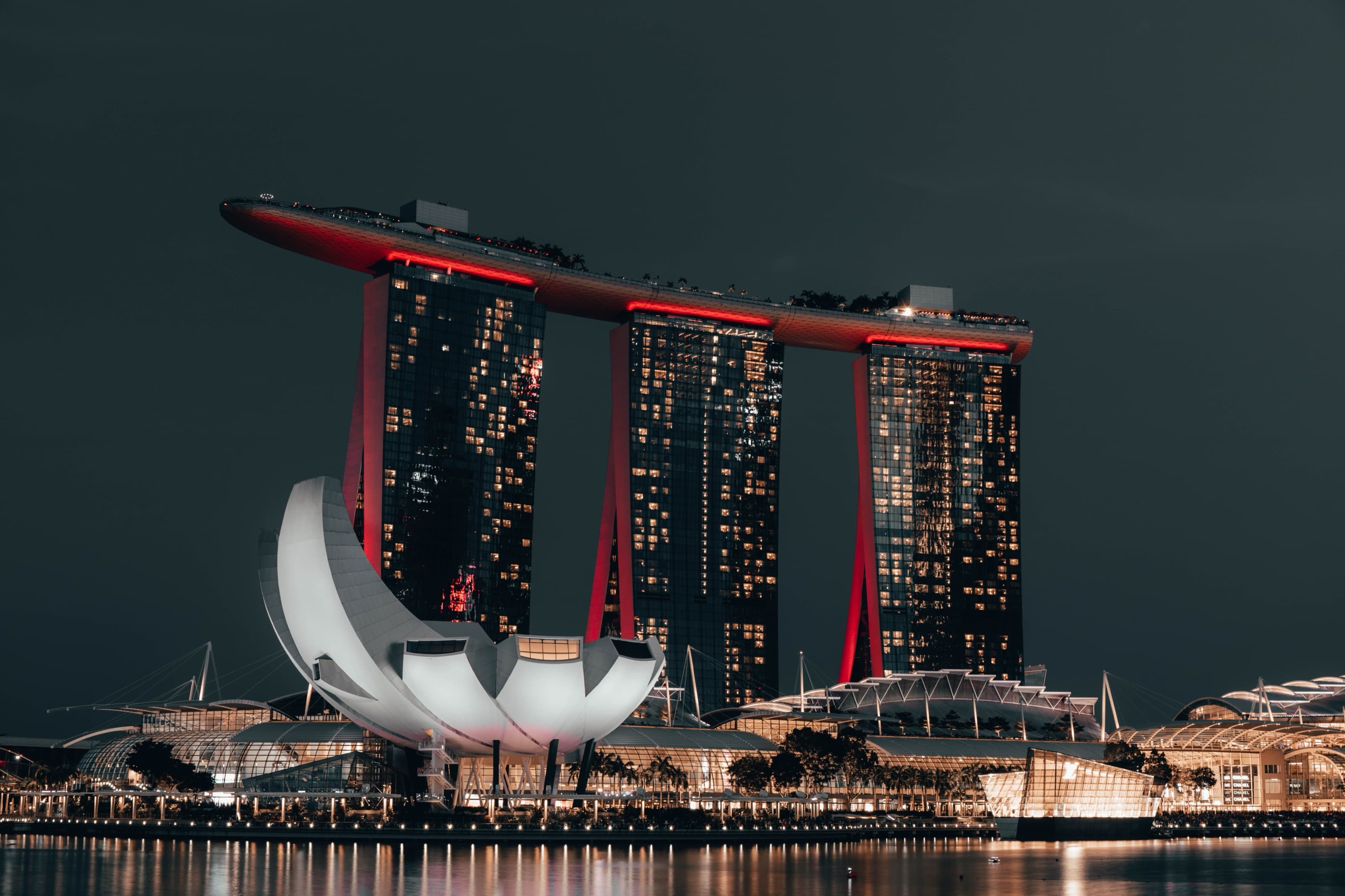 Marina Bay Sands skyline illuminated at night, reflected in the bay
