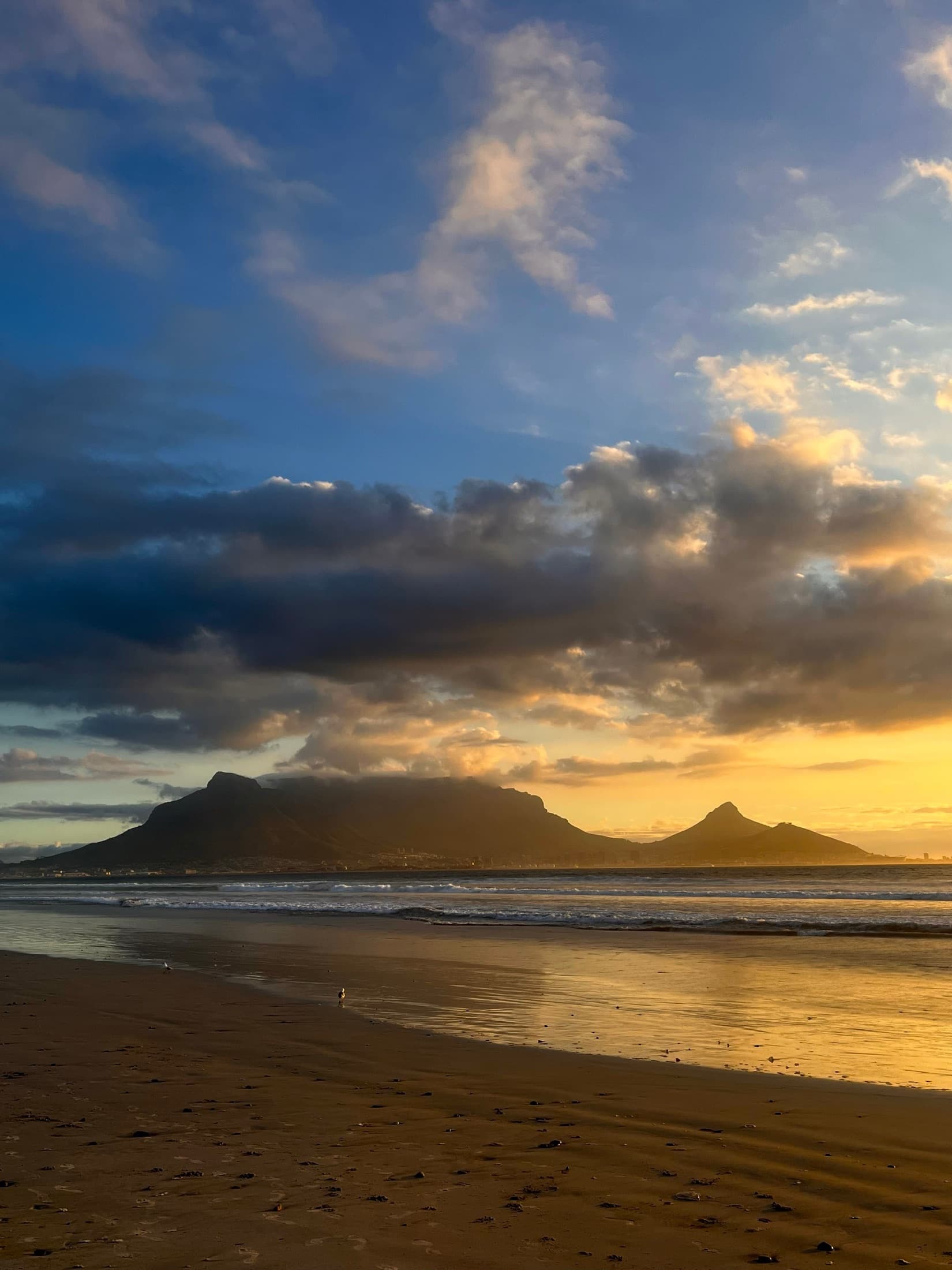 Serene view of Table Mountain at sunset from a sandy Cape Town beach