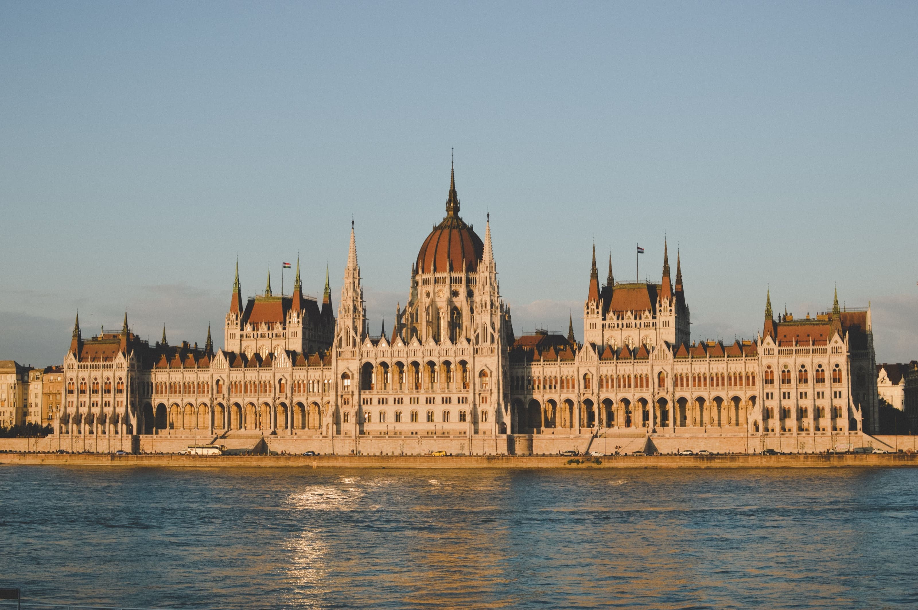 The Hungarian Parliament Building glowing at sunset along the banks of the Danube River
